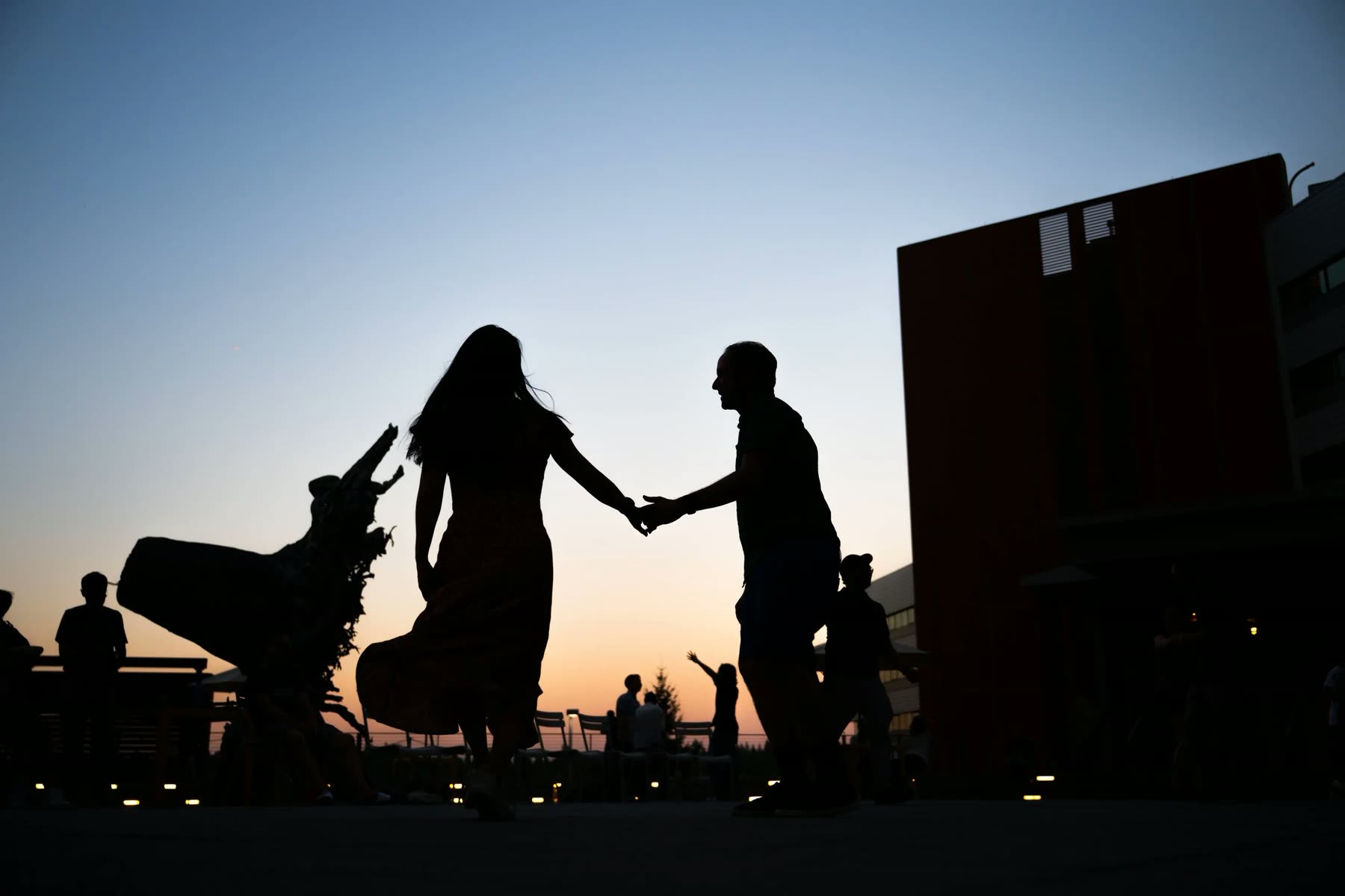 Two dancers' joined hands at a social dance in the evening.
